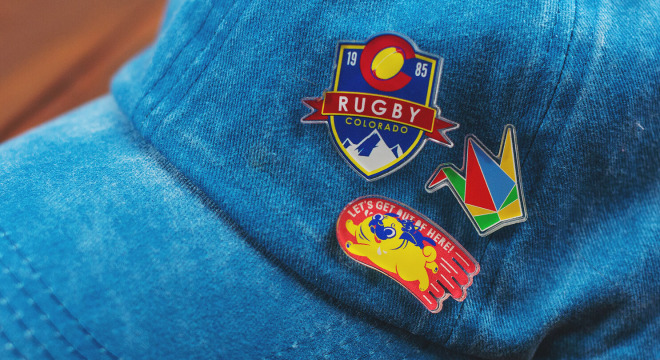 Custom hat pins on a blue denim baseball cap