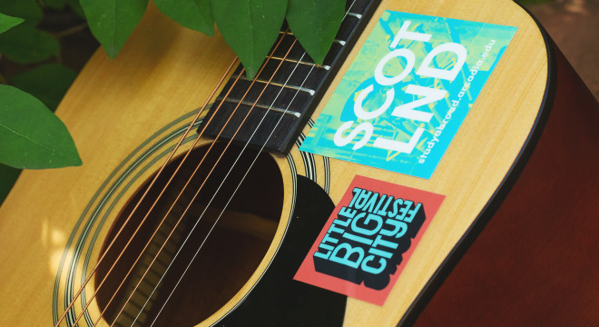custom square stickers placed on a guitar