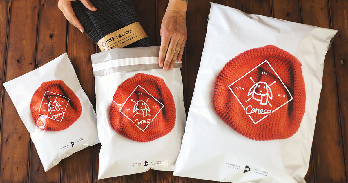 inserting a clothing product into custom poly bags for shipping ecommerce