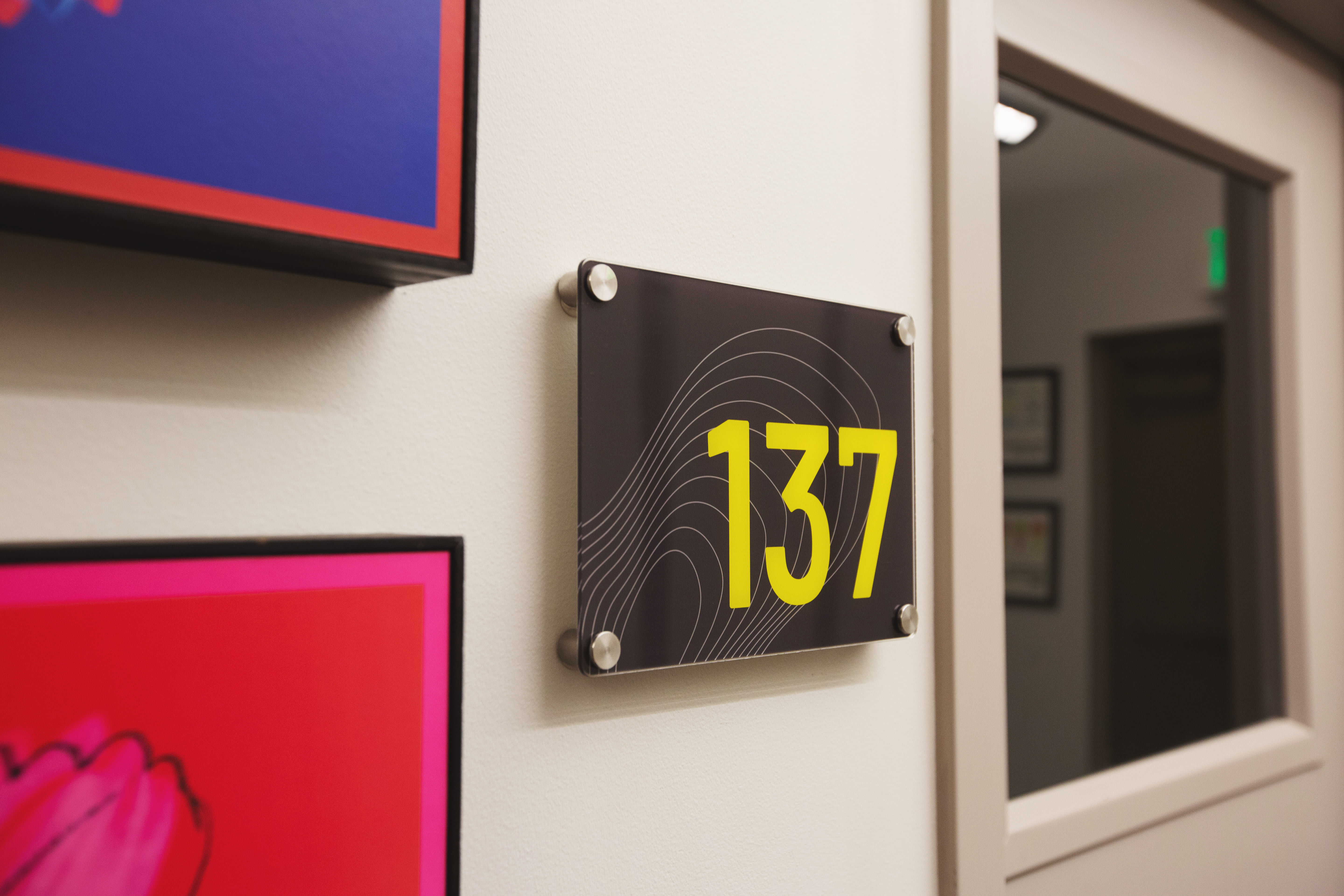 un panneau acrylique personnalisé noir indiquant un numéro de chambre