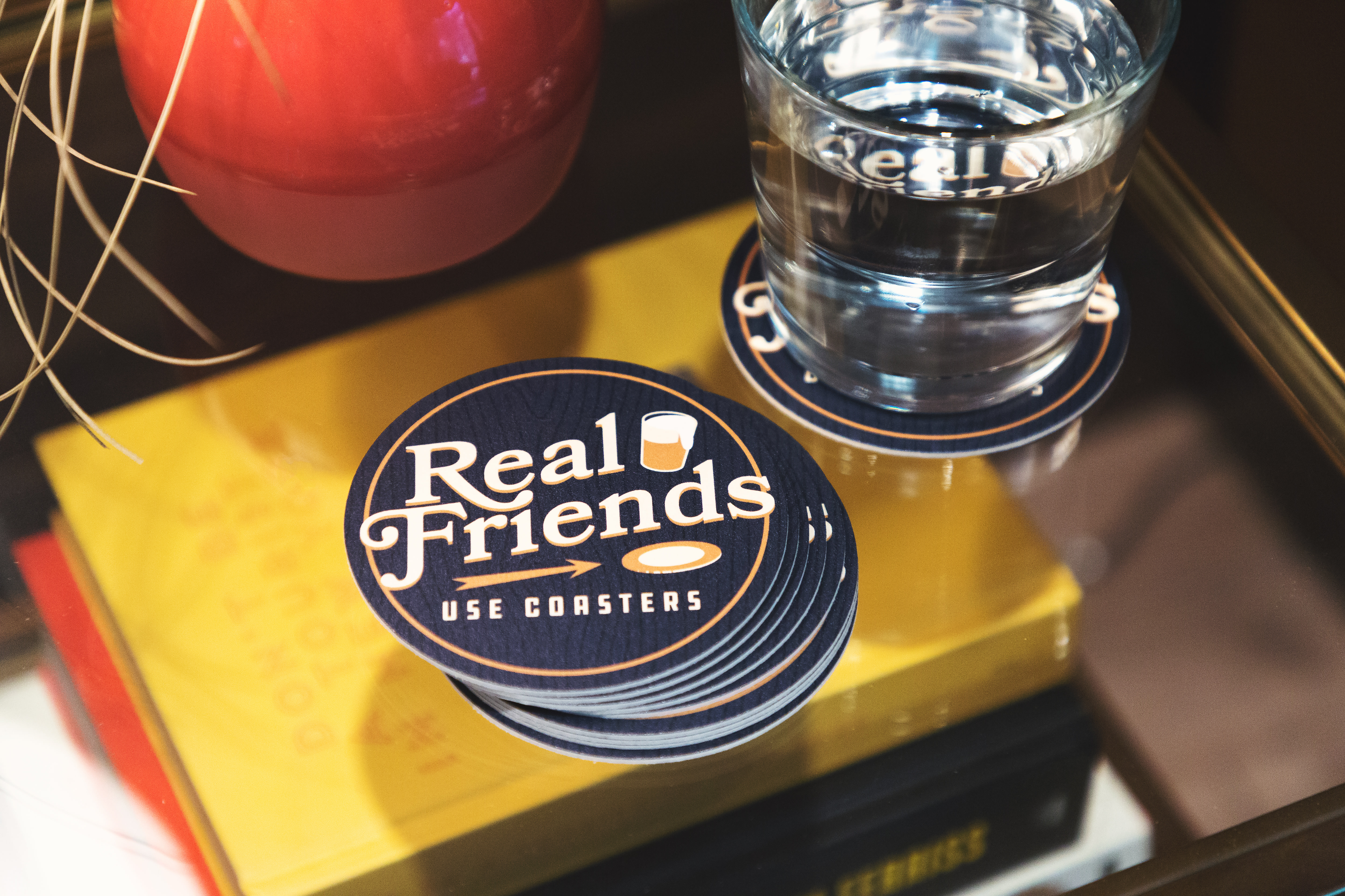 a stack of custom coasters that say real friends use coasters