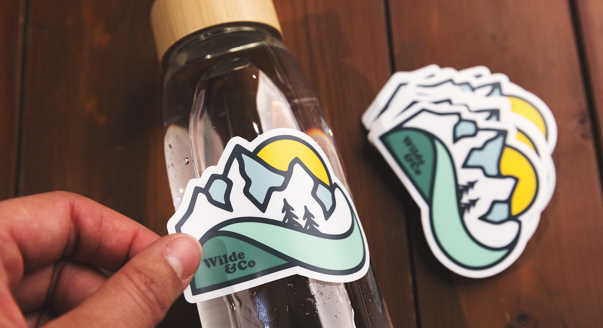 sticker personalizado de una montaña en una botella de agua de vidrio