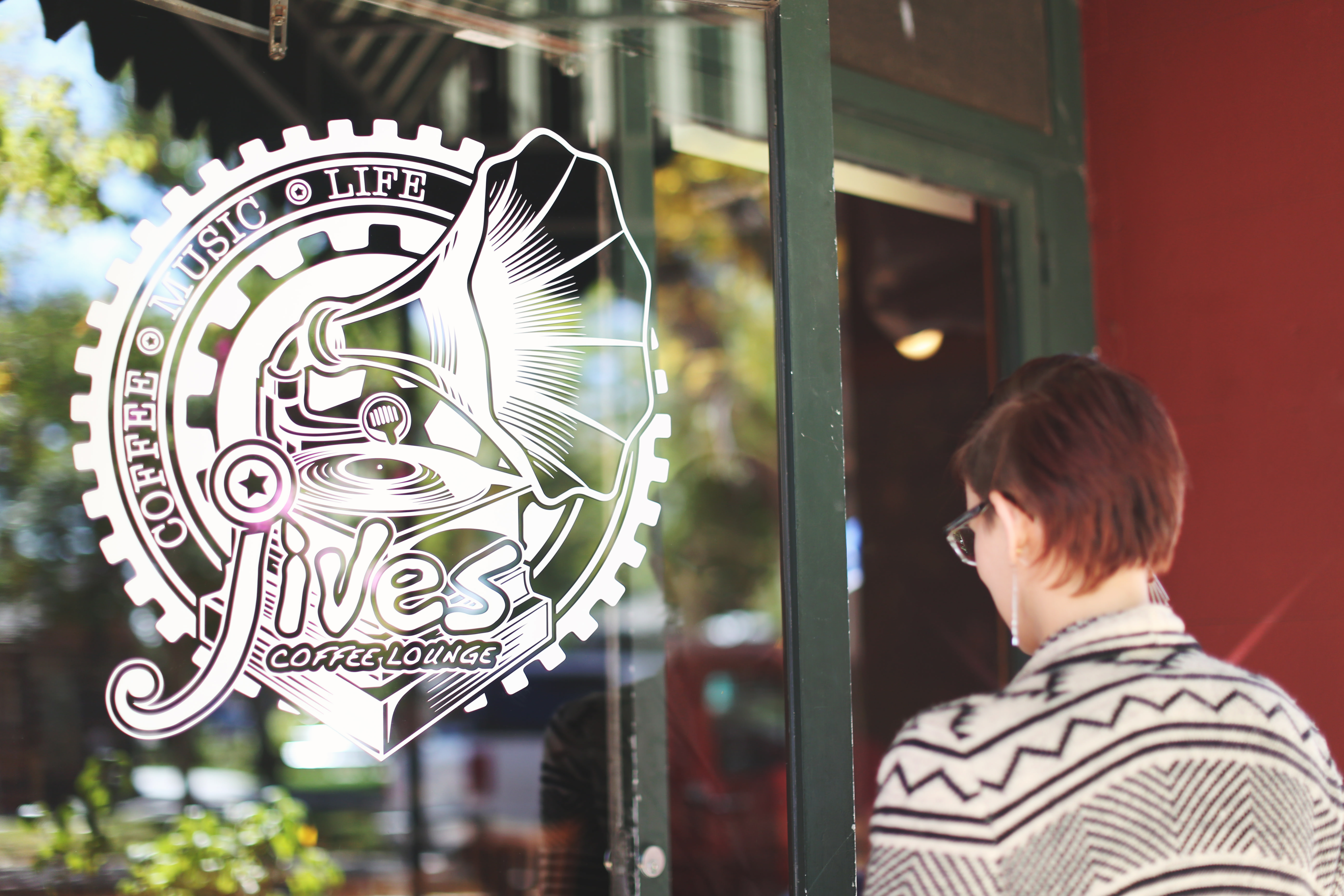 a customer looking at a large white custom transfer sticker on a storefront window