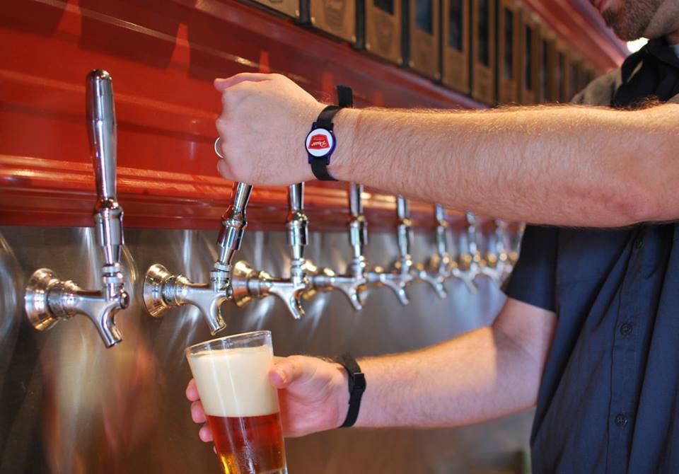 Pouring beer with custom stickers on RFID wristbands