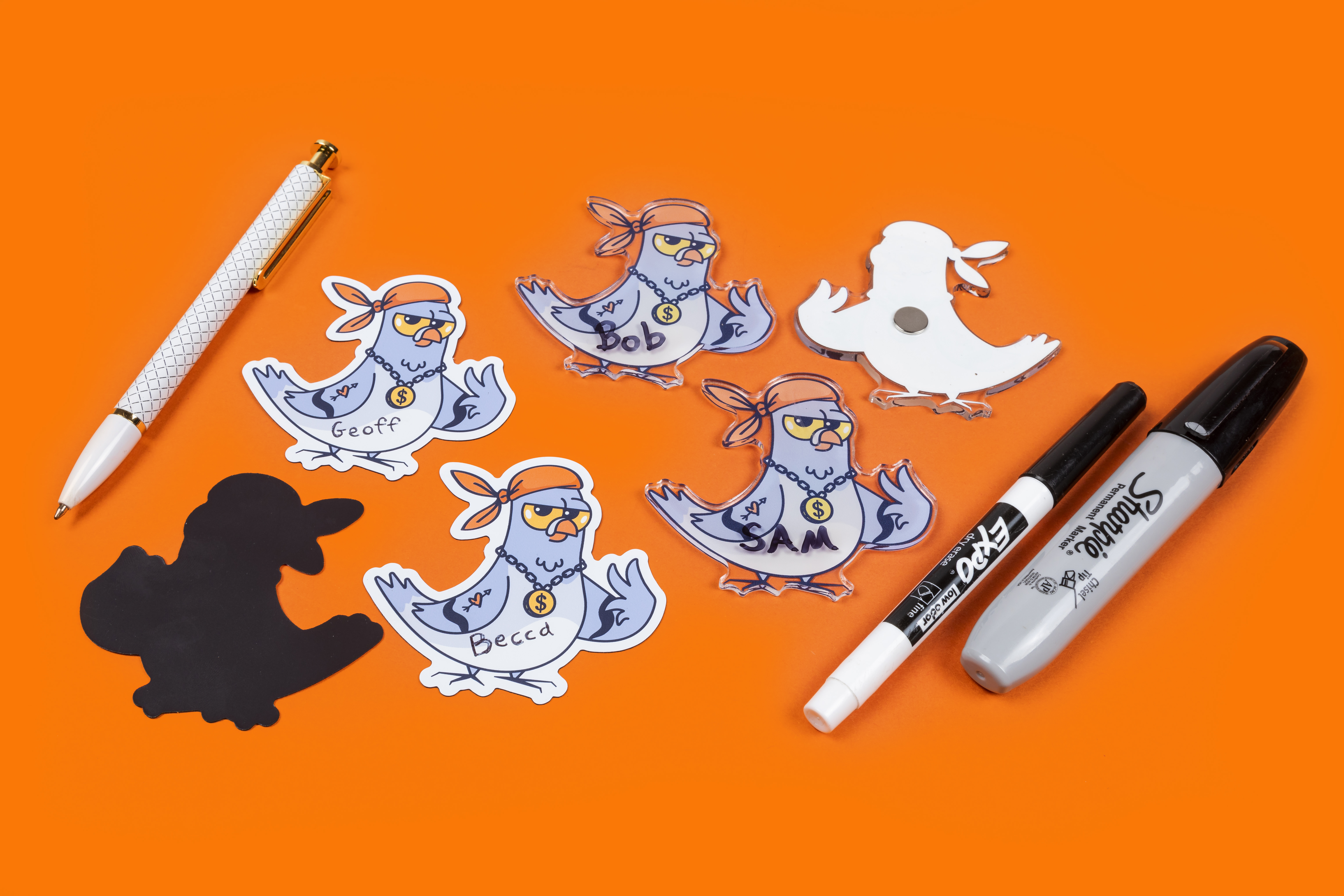 examples of standard and acrylic magnets with writing in pen and sharpie on an orange background