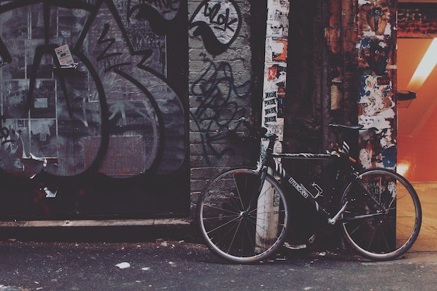 Ein mit Stickern bedecktes Fahrrad, das an einer Wand geparkt steht