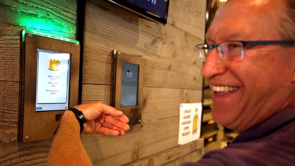 Man using RFID bracelet to pour his beer